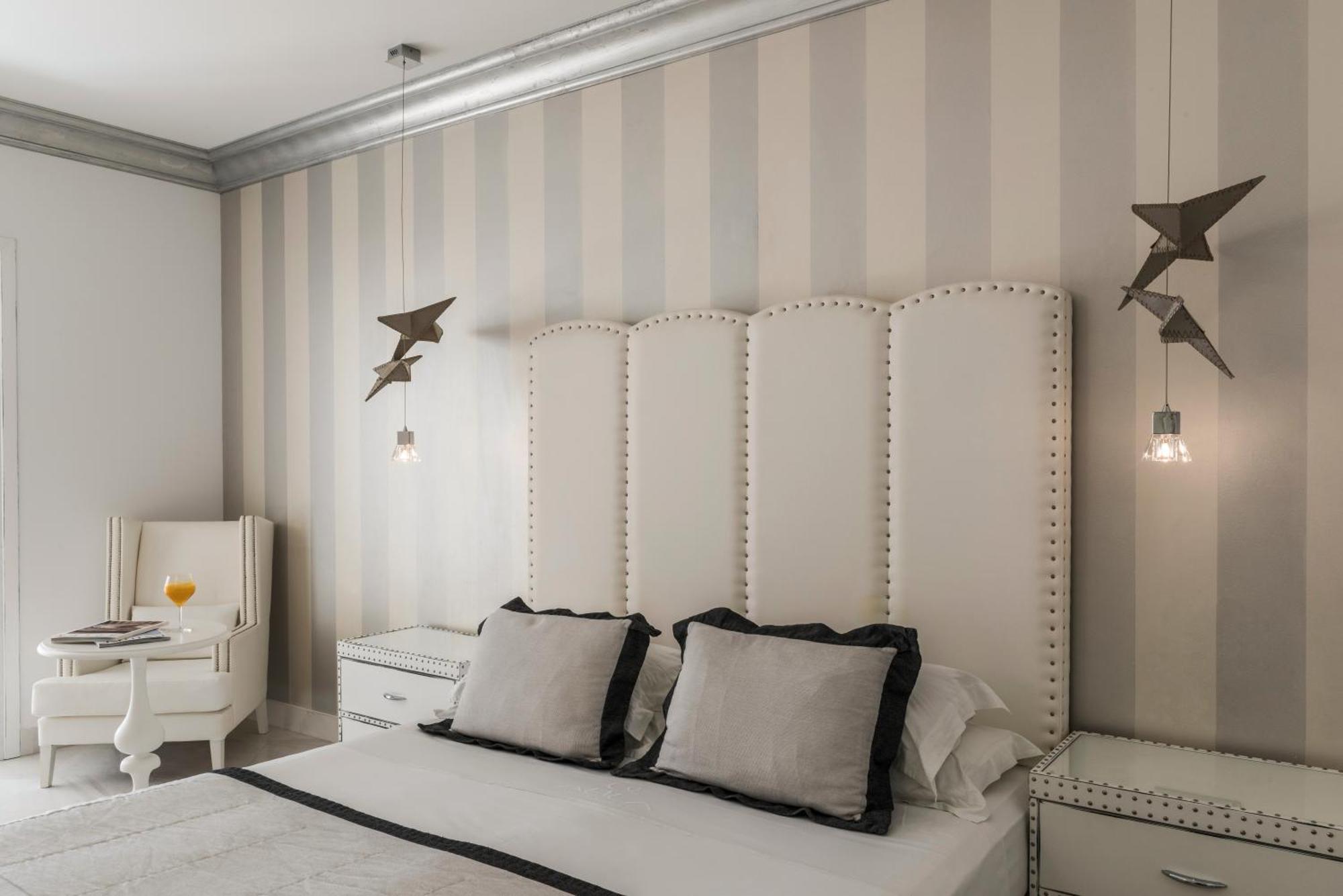 Mitsis Selection Alila Faliraki Quarto foto A bedroom with a bed, a nightstand, a chair, and a lamp